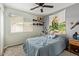 Simple bedroom with a ceiling fan, a window with blinds, and a neutral color scheme at 518 S 114Th Ave, Avondale, AZ 85323