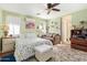 Comfortable bedroom featuring a ceiling fan, a cozy seating area, and a floral-patterned bedspread at 518 S 114Th Ave, Avondale, AZ 85323