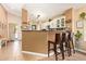 Bright kitchen featuring a breakfast bar with seating and sliding glass doors to the backyard at 518 S 114Th Ave, Avondale, AZ 85323