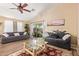 Bright and airy living room featuring wood floors, ceiling fan, and access to the outdoor patio at 518 S 114Th Ave, Avondale, AZ 85323