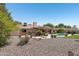 Spacious backyard featuring a pool, patio area, mature trees, and low-maintenance landscaping at 5410 E Poinsettia Dr, Scottsdale, AZ 85254