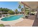 Resort-style backyard featuring a sparkling pool, covered patio, lush landscaping, and privacy at 5410 E Poinsettia Dr, Scottsdale, AZ 85254