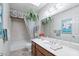 A bright primary bathroom features a large vanity with a sink, mirror, and a shower/tub combo at 5410 E Poinsettia Dr, Scottsdale, AZ 85254