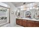 A primary bathroom features a double sink vanity with cherry cabinets and a soaking tub at 5410 E Poinsettia Dr, Scottsdale, AZ 85254