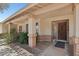 Inviting front porch with brick pillars and trim, a mature landscaping, and a solid wood front door at 5410 E Poinsettia Dr, Scottsdale, AZ 85254