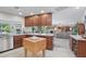 This kitchen features an island and breakfast bar, granite countertops, dark cabinets, and is adjacent to a living room at 5410 E Poinsettia Dr, Scottsdale, AZ 85254