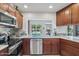 A kitchen features cherry cabinets, granite countertops, stainless steel appliances, and a view of the backyard swimming pool at 5410 E Poinsettia Dr, Scottsdale, AZ 85254