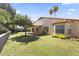 Large grassy backyard with a covered patio and mature trees at 5450 E Paradise Ln, Scottsdale, AZ 85254
