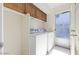 Convenient laundry room features a washer, dryer, and built-in cabinetry for storage at 5450 E Paradise Ln, Scottsdale, AZ 85254