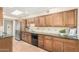 Charming kitchen with terracotta tile flooring, wooden cabinetry, and stainless steel appliances at 6025 N 10Th Pl, Phoenix, AZ 85014