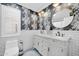 Elegantly designed bathroom featuring floral wallpaper, double vanities, and round mirrors at 6708 W Utopia Rd, Glendale, AZ 85308