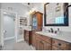 A light-filled bathroom featuring double vanities, wooden cabinets, and elegant mirrors at 6708 W Utopia Rd, Glendale, AZ 85308