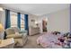 Charming bedroom featuring a glider, large window, and an organized walk-in closet at 6708 W Utopia Rd, Glendale, AZ 85308