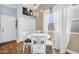 Charming dining area with white furniture, a round table, and natural light from the window at 6708 W Utopia Rd, Glendale, AZ 85308