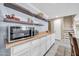Convenient kitchenette with modern microwave, ample counter space, and stylish floating shelves at 6708 W Utopia Rd, Glendale, AZ 85308