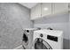 Well-equipped laundry room with modern washer and dryer, plus patterned wallpaper at 6708 W Utopia Rd, Glendale, AZ 85308