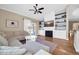 Bright, open living room with a comfortable seating area, fireplace, and hardwood flooring at 6708 W Utopia Rd, Glendale, AZ 85308