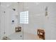 This luxurious shower showcases bright white tile, glass block window, and convenient teak benches at 6708 W Utopia Rd, Glendale, AZ 85308