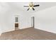 Carpeted bedroom with a ceiling fan, adjacent bathroom, and neutral color palette at 674 E Renegade Pl, San Tan Valley, AZ 85143