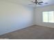Cozy bedroom featuring carpet flooring, a ceiling fan, and bright natural light from a large window at 674 E Renegade Pl, San Tan Valley, AZ 85143
