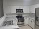 Well-lit kitchen featuring stainless steel appliances, sleek white cabinetry, and durable countertops at 674 E Renegade Pl, San Tan Valley, AZ 85143