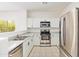 Bright kitchen with stainless steel appliances, white cabinets, ample countertop space and natural light at 674 E Renegade Pl, San Tan Valley, AZ 85143