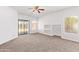 Spacious living area with plush carpet, a ceiling fan and ample natural light from two large windows at 674 E Renegade Pl, San Tan Valley, AZ 85143