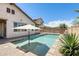 Private backyard featuring a pool and patio area with umbrella, surrounded by desert landscaping at 699 S 197Th Dr, Buckeye, AZ 85326