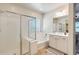 Bright bathroom featuring a glass-enclosed shower, a soaking tub, and bright vanity at 699 S 197Th Dr, Buckeye, AZ 85326