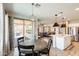 Cozy dining area with a modern chandelier, adjacent to the kitchen and living area at 699 S 197Th Dr, Buckeye, AZ 85326