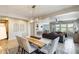 Open-concept living and dining area, showcasing neutral walls, tile flooring, and backyard views from the dining table at 699 S 197Th Dr, Buckeye, AZ 85326