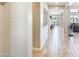 Hallway with wood-look tile flooring, neutral walls, and decor details leading to common areas and the backyard at 699 S 197Th Dr, Buckeye, AZ 85326