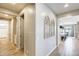Hallway with wood-look tile flooring, neutral walls, and decor details with easy access to rooms and common areas at 699 S 197Th Dr, Buckeye, AZ 85326