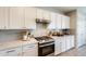 Close-up of the kitchen with modern cabinets, stainless steel stove, and stylish backsplash for cooking enthusiasts at 699 S 197Th Dr, Buckeye, AZ 85326