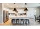 The kitchen is equipped with stainless steel appliances, white cabinets, an island with seating, and pendant lighting at 699 S 197Th Dr, Buckeye, AZ 85326