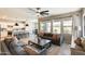 Bright living room featuring tile floors, a ceiling fan, and access to the backyard and kitchen at 699 S 197Th Dr, Buckeye, AZ 85326