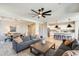 Open-concept living room features a comfortable couch, ceiling fan, and seamless flow into the dining area and kitchen at 699 S 197Th Dr, Buckeye, AZ 85326