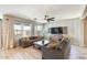 Living room featuring a modern sofa, neutral walls, tile flooring, natural light, and backyard views at 699 S 197Th Dr, Buckeye, AZ 85326