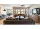 Spacious living room featuring a ceiling fan, modern sofa, backyard views, and access to the dining area at 699 S 197Th Dr, Buckeye, AZ 85326