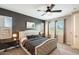 This main bedroom features a large decorative headboard, ceiling fan, and two windows at 699 S 197Th Dr, Buckeye, AZ 85326