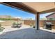 Covered patio area with dining set and grill, creating an inviting outdoor living space at 699 S 197Th Dr, Buckeye, AZ 85326