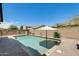 Private in-ground pool with umbrella and desert landscaping, perfect for outdoor relaxation and entertaining at 699 S 197Th Dr, Buckeye, AZ 85326