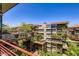 Wide exterior view of condos with rooftop plants, metal safety railing, connecting walkways, and blue skies at 7151 E Rancho Vista Dr # 6002, Scottsdale, AZ 85251