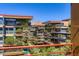 Exterior view of neighborhood condominiums with many plants, metal railings, and a mountain peak in the distance at 7151 E Rancho Vista Dr # 6002, Scottsdale, AZ 85251