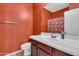 Stylish bathroom features a white sink vanity with dark wood cabinets and rust-colored walls at 742 E Kingbird Dr, Gilbert, AZ 85297