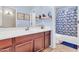 Bathroom featuring a vanity with a sink, mirror, and a bathtub with blue patterned shower curtain at 742 E Kingbird Dr, Gilbert, AZ 85297