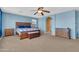 Primary bedroom featuring a ceiling fan, a wooden bed, a carpet floor and blue walls at 742 E Kingbird Dr, Gilbert, AZ 85297