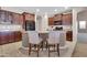 Kitchen with black refrigerator, granite countertop island, and wooden cabinets at 742 E Kingbird Dr, Gilbert, AZ 85297