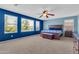 Spacious main bedroom with blue accent wall, large windows, and a ceiling fan at 742 E Kingbird Dr, Gilbert, AZ 85297