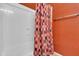 Bright shower with glass doors and colorful patterned shower curtain against an orange wall at 742 E Kingbird Dr, Gilbert, AZ 85297